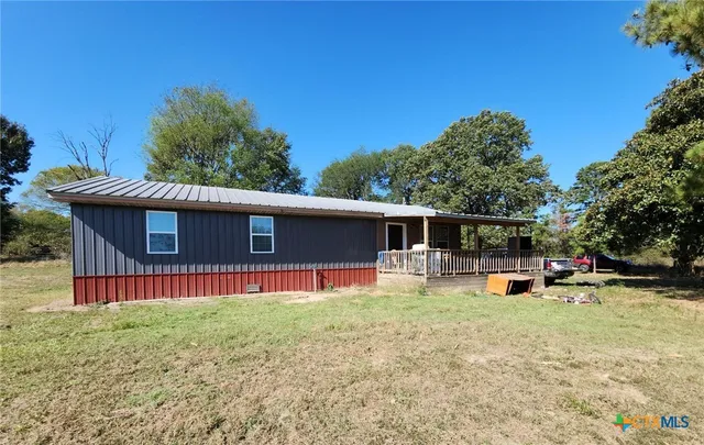 a view of a house with a yard and sitting area
