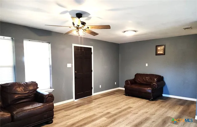 a living room with furniture and a ceiling fan
