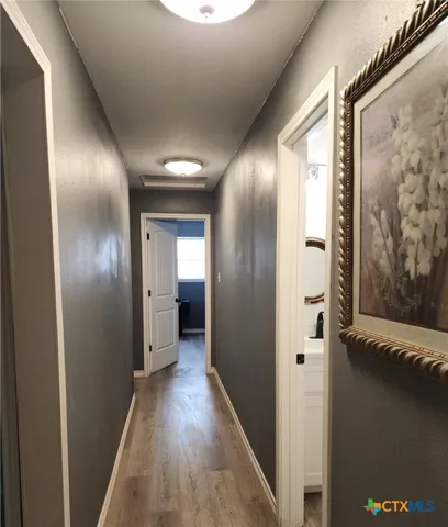 a view of a hallway with wooden floor