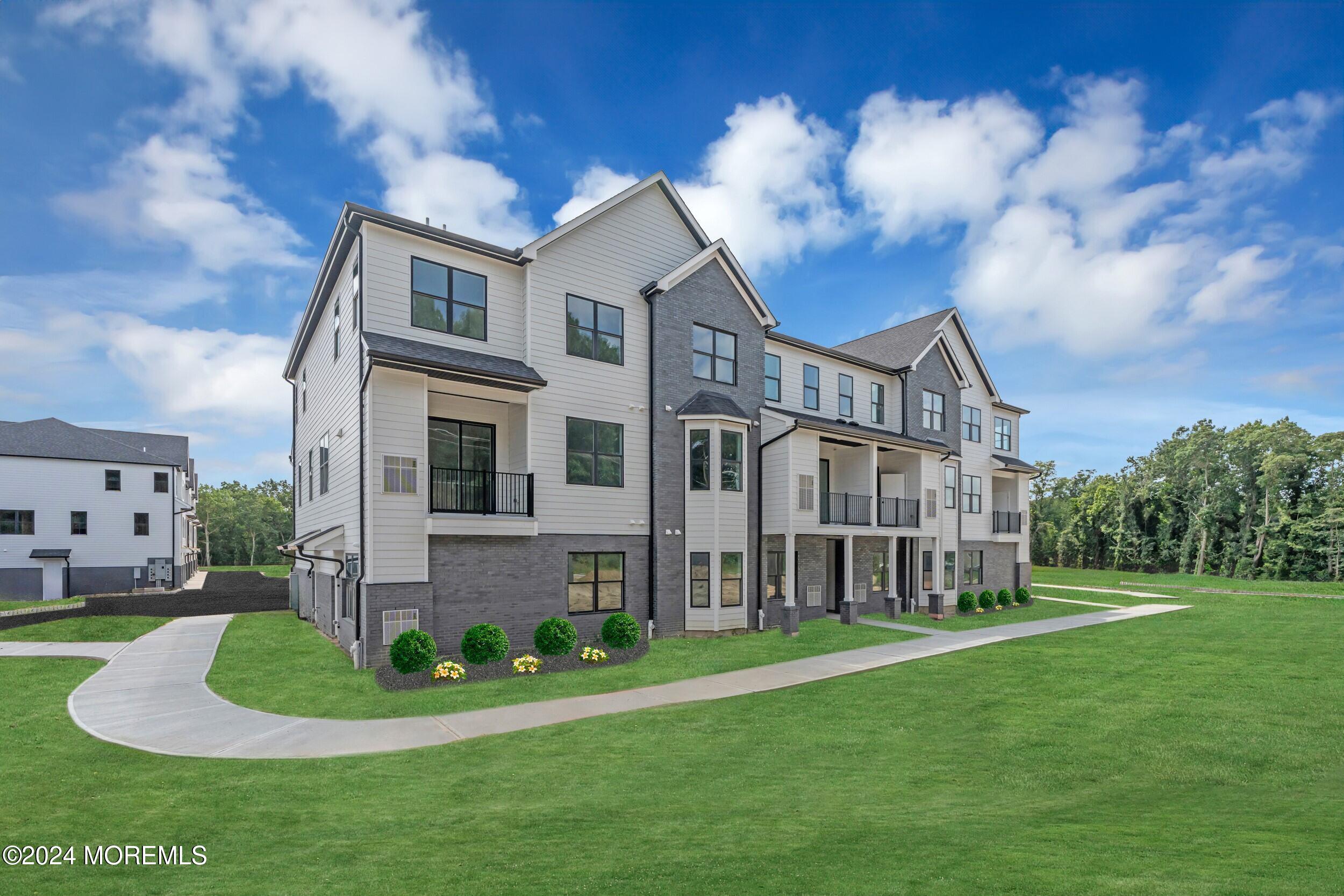 a view of a white house with a big yard and potted plants