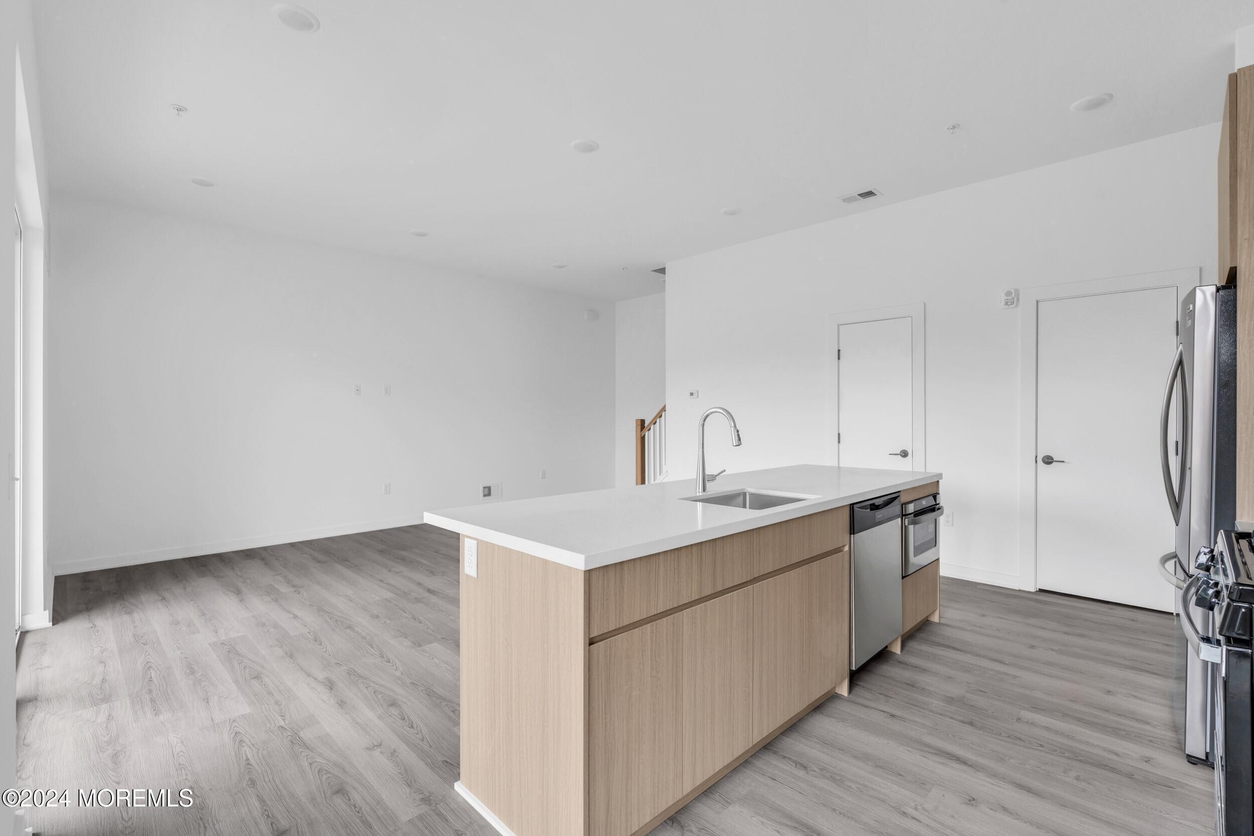 603 Texas Road Old Bridge, NJ 08857 - Photo 2 of 17 a kitchen with a sink cabinets stainless steel appliances and wooden floor