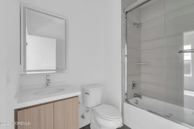 a bathroom with a bathtub shower sink vanity and toilet