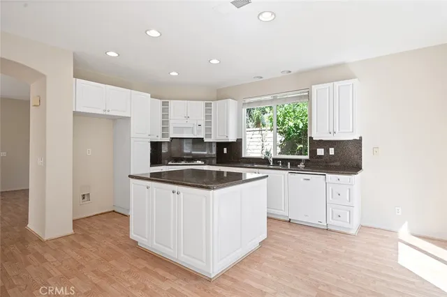 a kitchen with granite countertop a stove and a sink