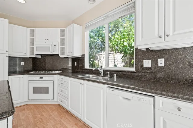 a kitchen with granite countertop a sink and a large window