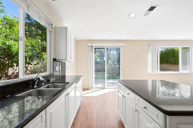 a kitchen with granite countertop a stove top oven and cabinets
