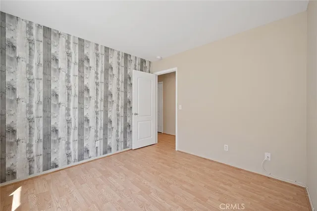 an empty room with a window and a ceiling fan