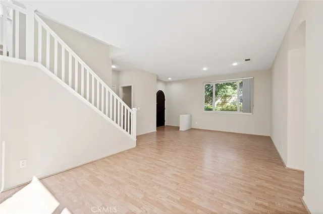 a view of an empty room with a window and a fireplace