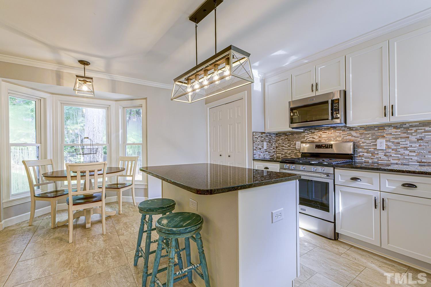 10009 Kilnstone Lane Raleigh, NC 27613 - Photo 2 of 12 TWO PANTRIES and an ISLAND with counter seating, just a few of the additional features of this bright open kitchen.