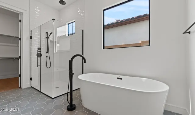 a bathroom with a tub sink and mirror