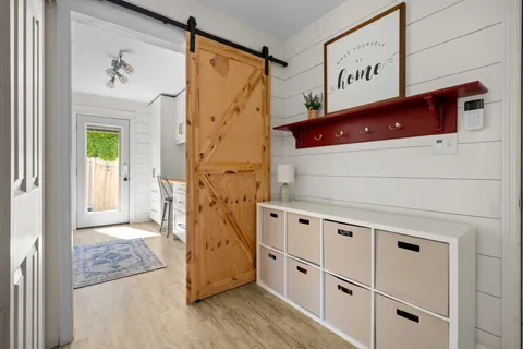 a kitchen with white cabinets and wooden floor