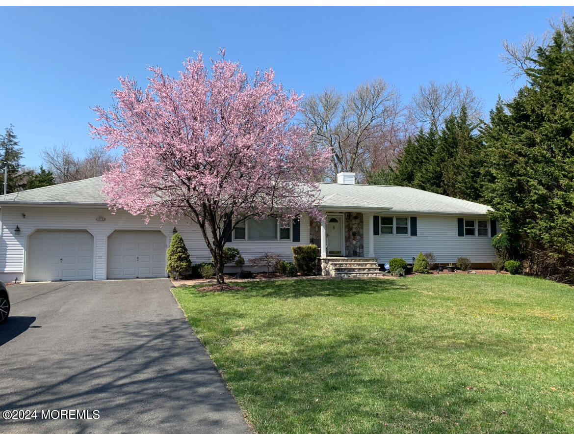 51 Lloyd Road Morganville, NJ 07751 - Photo 1 of 54 a yellow house with a yard and large trees