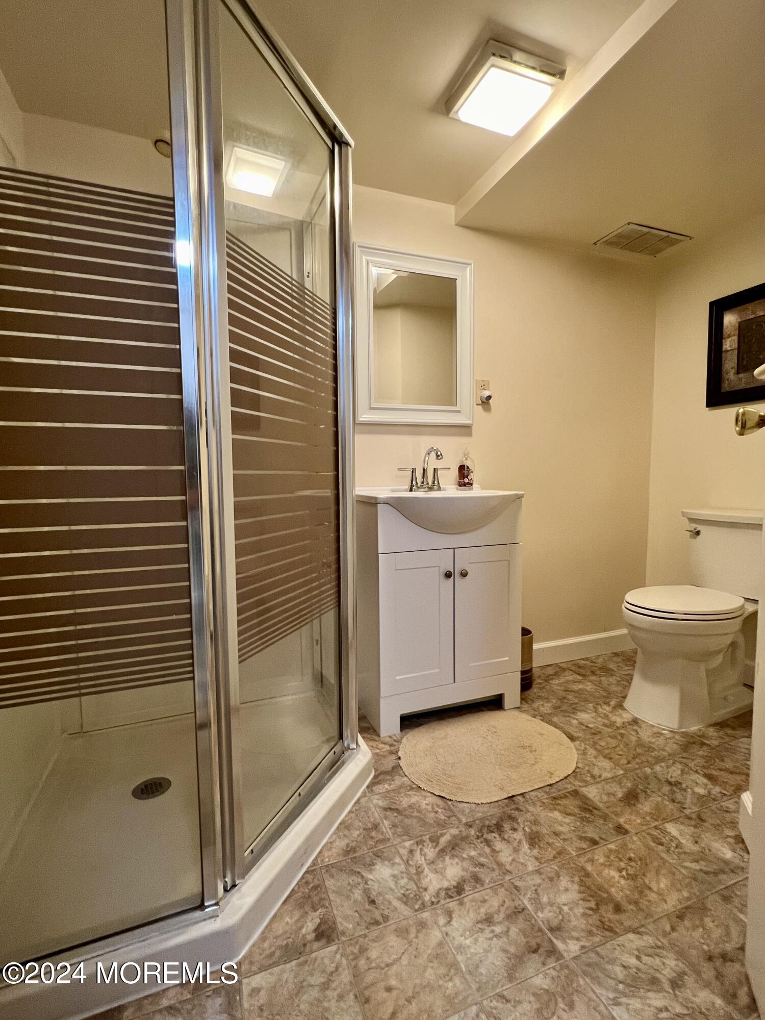 51 Lloyd Road Morganville, NJ 07751 - Photo 37 of 54 a bathroom with a granite countertop sink a toilet and shower
