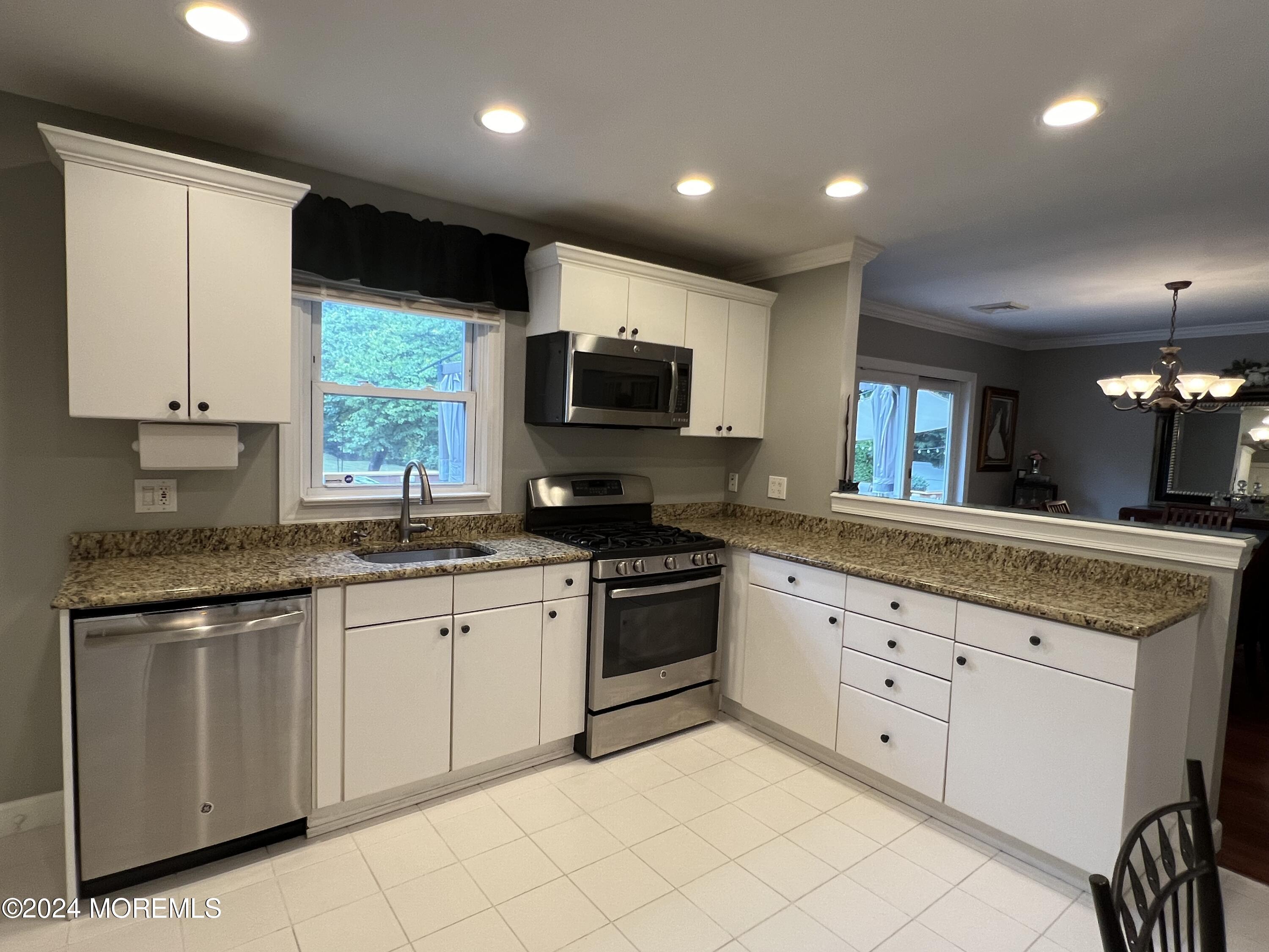 51 Lloyd Road Morganville, NJ 07751 - Photo 8 of 54 a kitchen with granite countertop white cabinets and white appliances