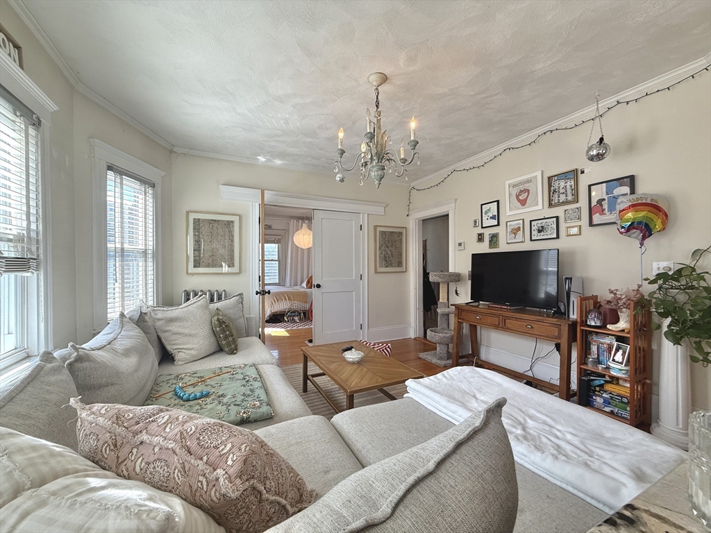 263 Powder House Boulevard, Unit 2 Somerville, MA 02144 - Photo 1 of 17 a living room with furniture and a flat screen tv