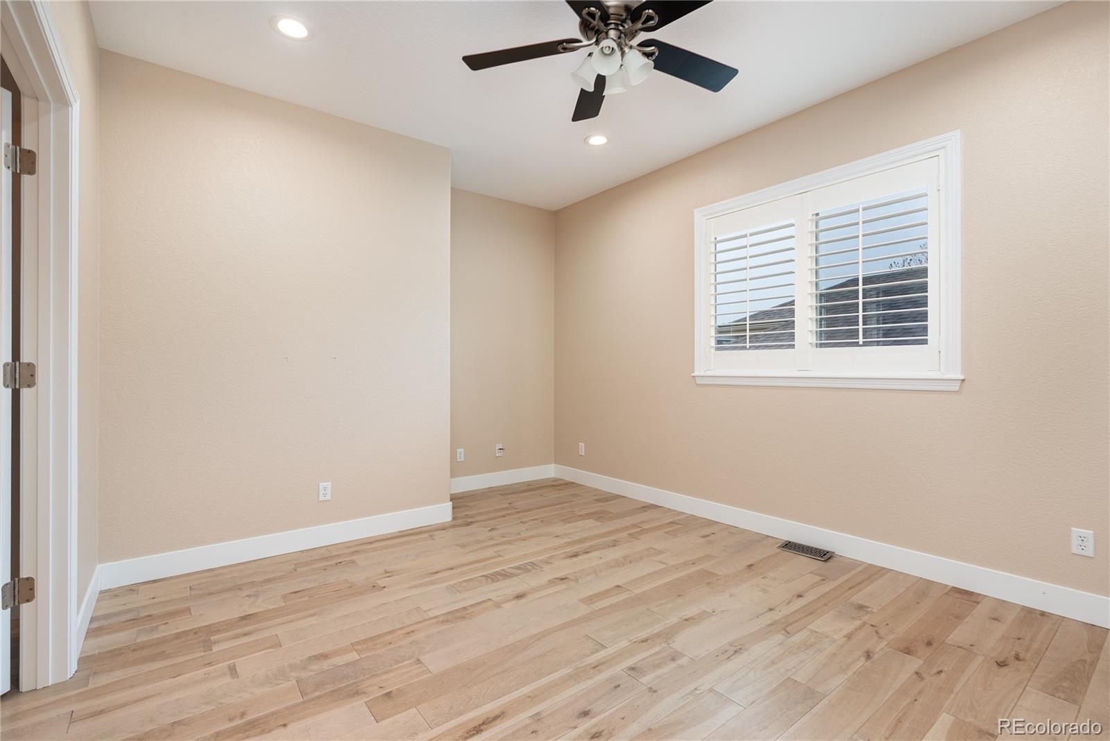 10960 Glengate Circle Highlands Ranch, CO 80130 - Photo 35 of 50 a view of an empty room with wooden floor and a window