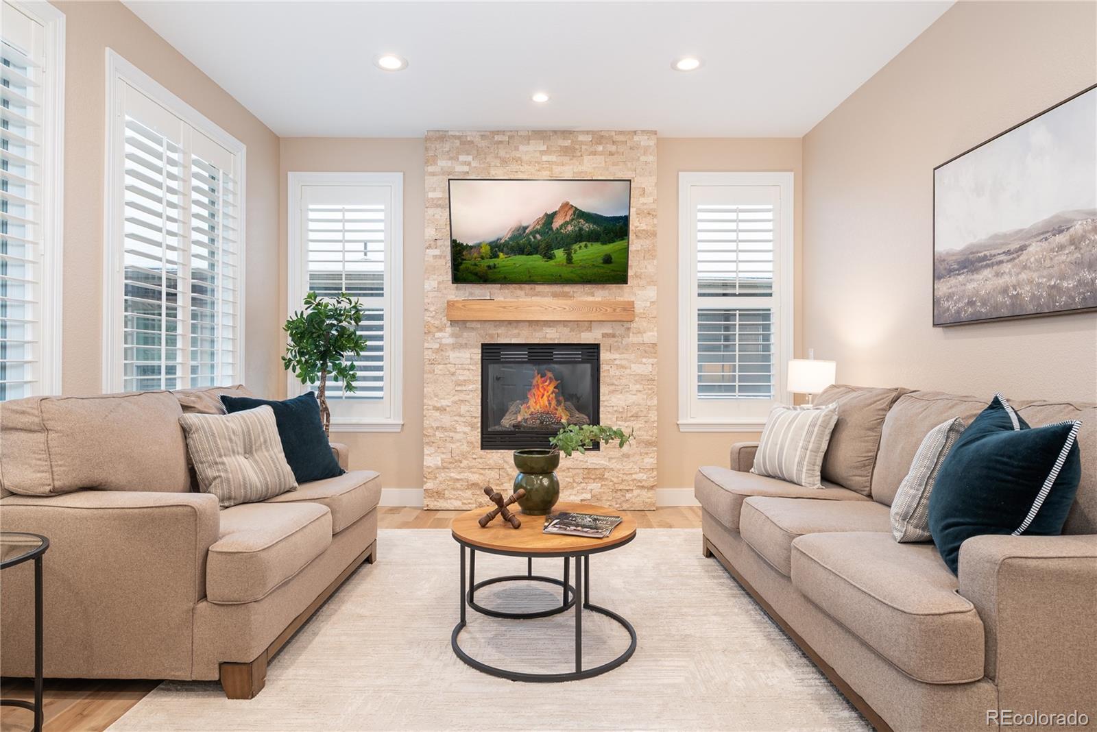 10960 Glengate Circle Highlands Ranch, CO 80130 - Photo 6 of 50 a living room with furniture a large window and a fireplace
