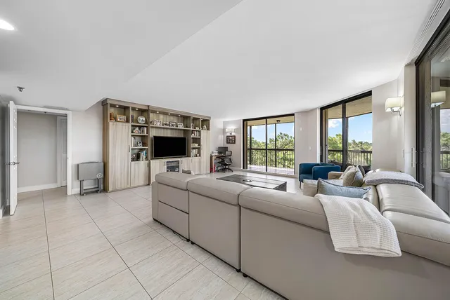 a living room with furniture a flat screen tv and a large window