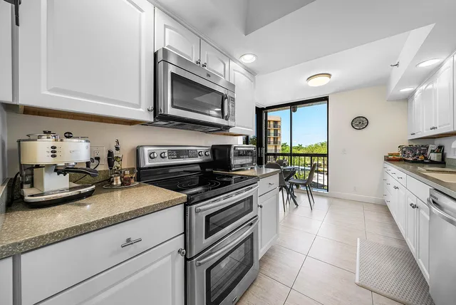 a kitchen with granite countertop a sink and stainless steel appliances