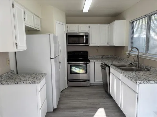 a kitchen with a sink stove and refrigerator