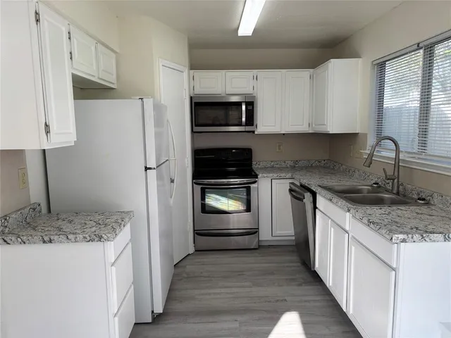 a kitchen with a sink stove and refrigerator