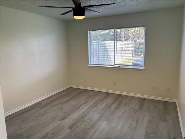 an empty room with a window and a ceiling fan