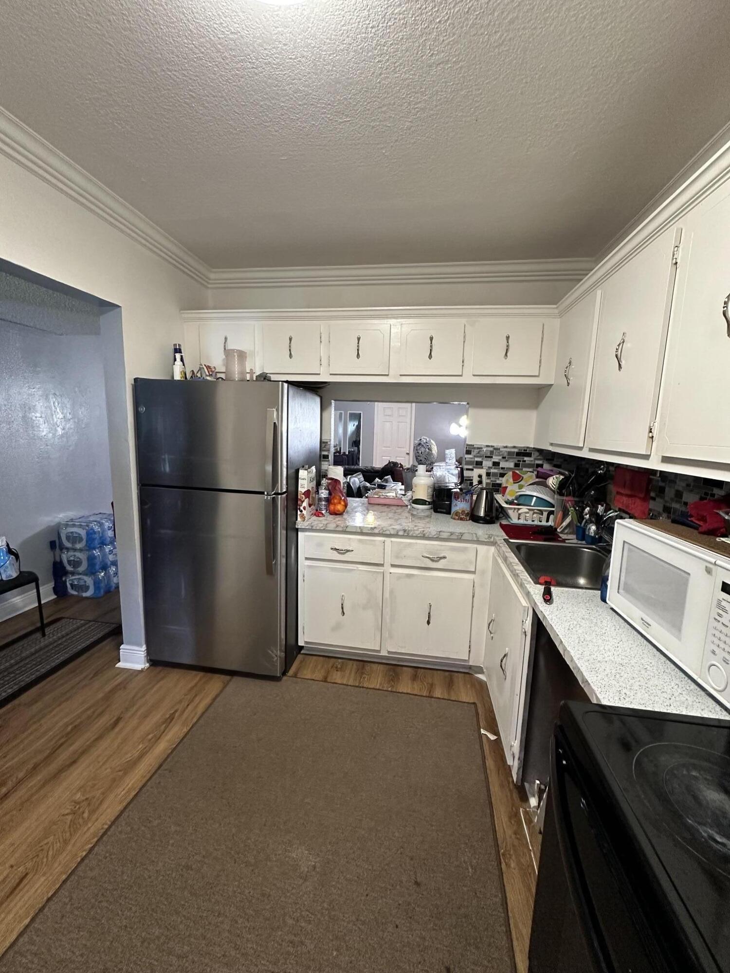 8341 Sands Point Boulevard, Unit B206 Tamarac, FL 33321 - Photo 4 of 11 a kitchen with a refrigerator a stove a sink and cabinets