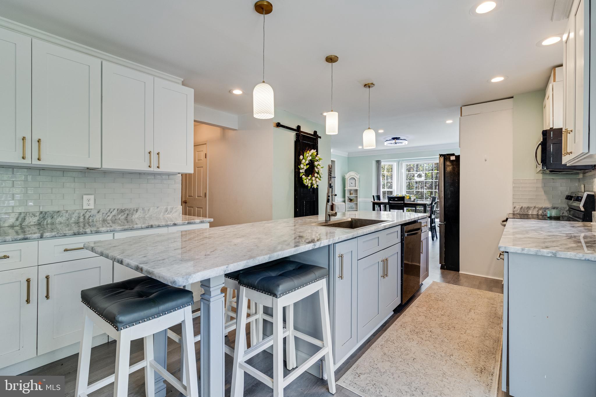8442 Delegate Drive King George, VA 22485 - Photo 11 of 42 a kitchen with stainless steel appliances kitchen island a table chairs sink and cabinets