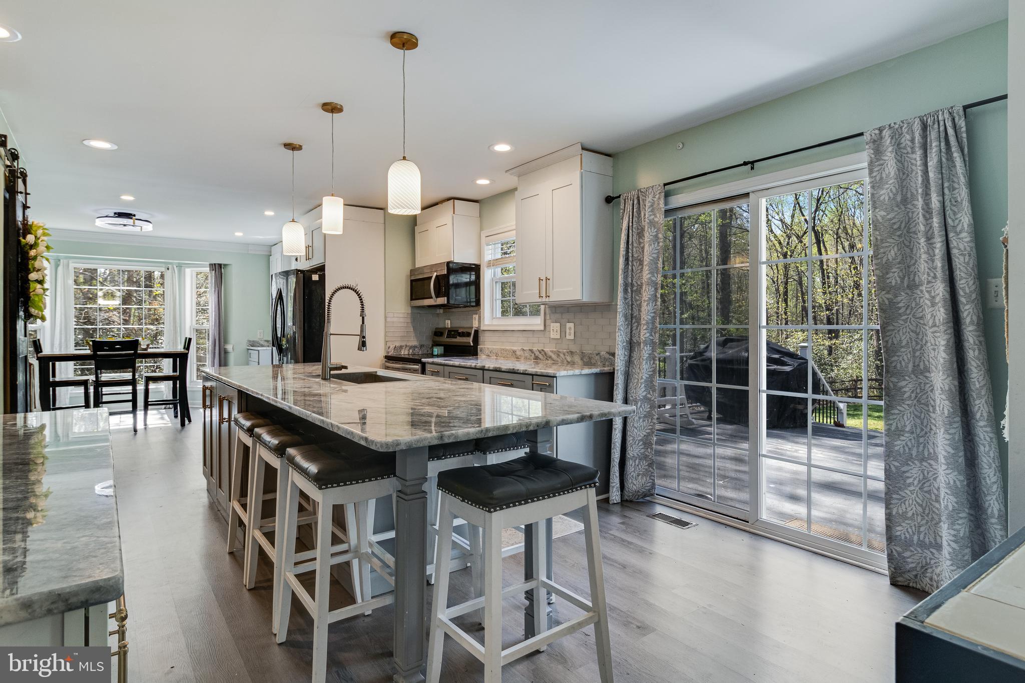 8442 Delegate Drive King George, VA 22485 - Photo 12 of 42 a kitchen with granite countertop a stove a sink a dining table and chairs