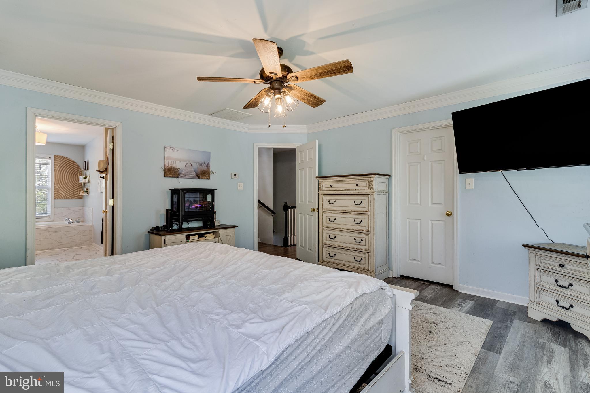 8442 Delegate Drive King George, VA 22485 - Photo 29 of 42 a bedroom with a bed a mirror and a flat tv screen on dresser
