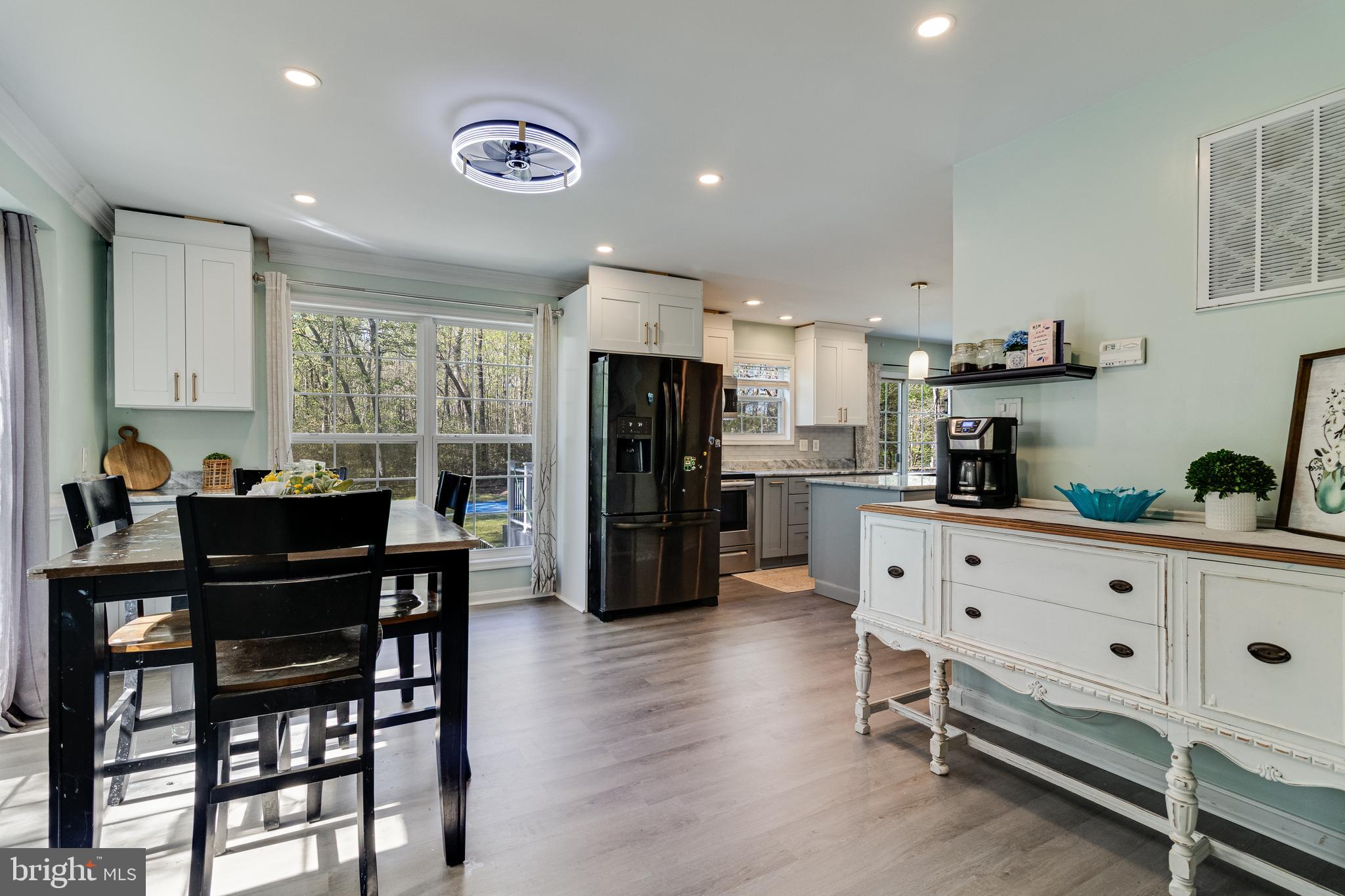 8442 Delegate Drive King George, VA 22485 - Photo 5 of 42 a kitchen with stainless steel appliances kitchen island granite countertop a refrigerator a stove a dining table and chairs with wooden floor