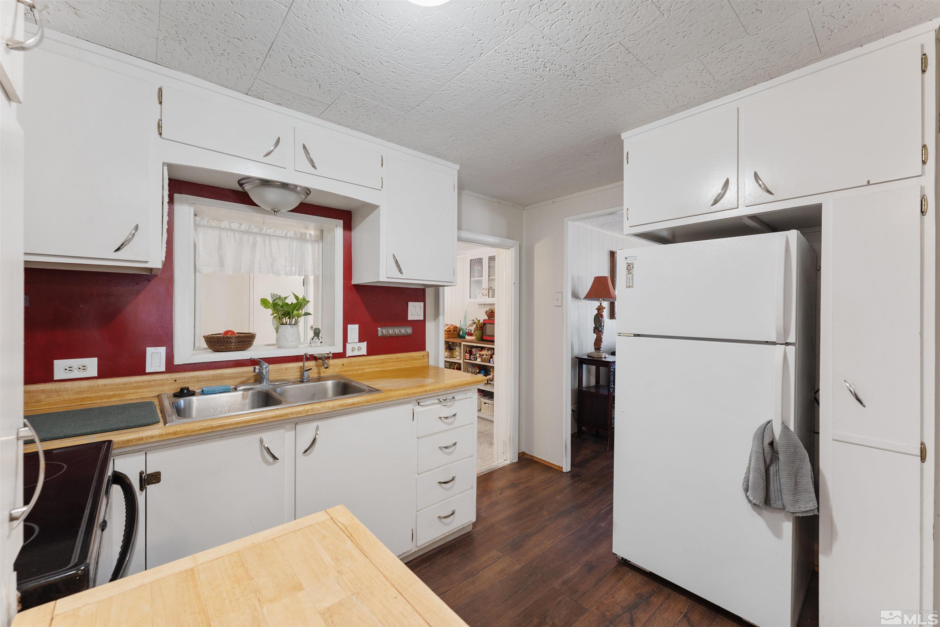 467 Magnolia Way Reno, NV 89506 - Photo 13 of 40 a kitchen with a refrigerator a sink and dishwasher with wooden floor