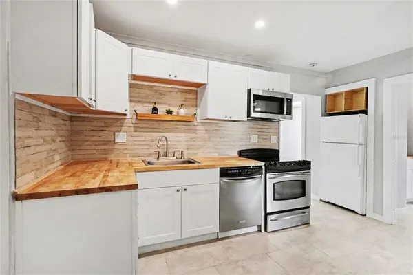 a kitchen with stainless steel appliances granite countertop a sink and a stove top oven