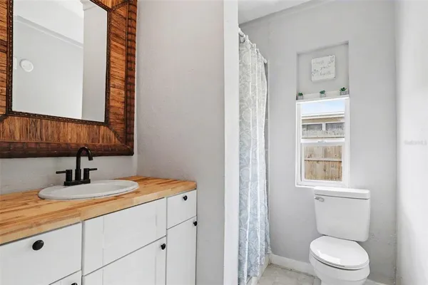 a bathroom with a toilet sink vanity and mirror