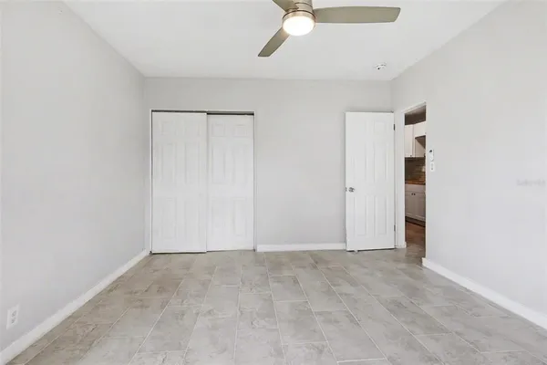 an empty room with closet and windows