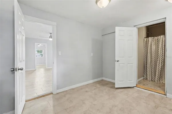 an empty room with closet and a hallway