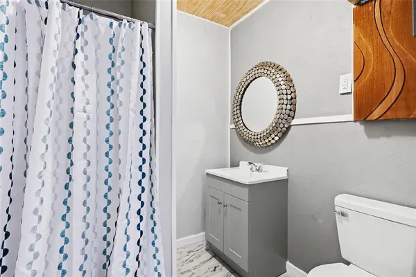 a bathroom with a toilet a sink and a mirror