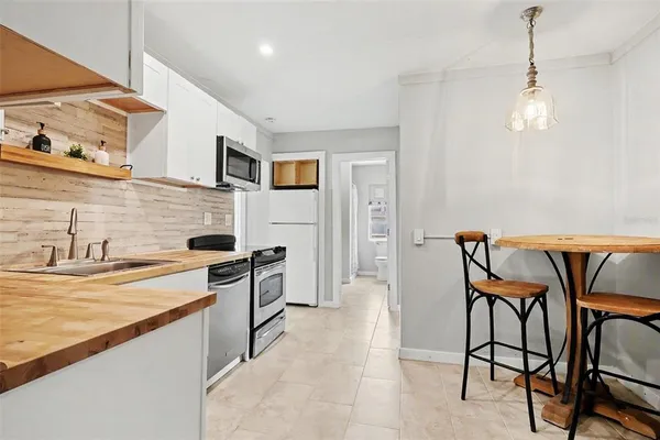 a kitchen with stainless steel appliances granite countertop a sink and a refrigerator