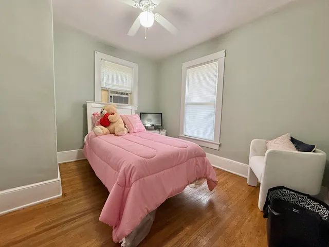 a bedroom with a bed and wooden floor