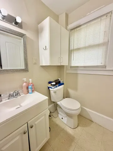 a bathroom with a sink and mirror with toilet