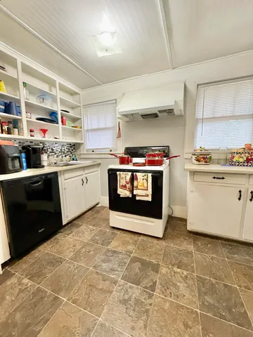 a kitchen with a stove sink and cabinets