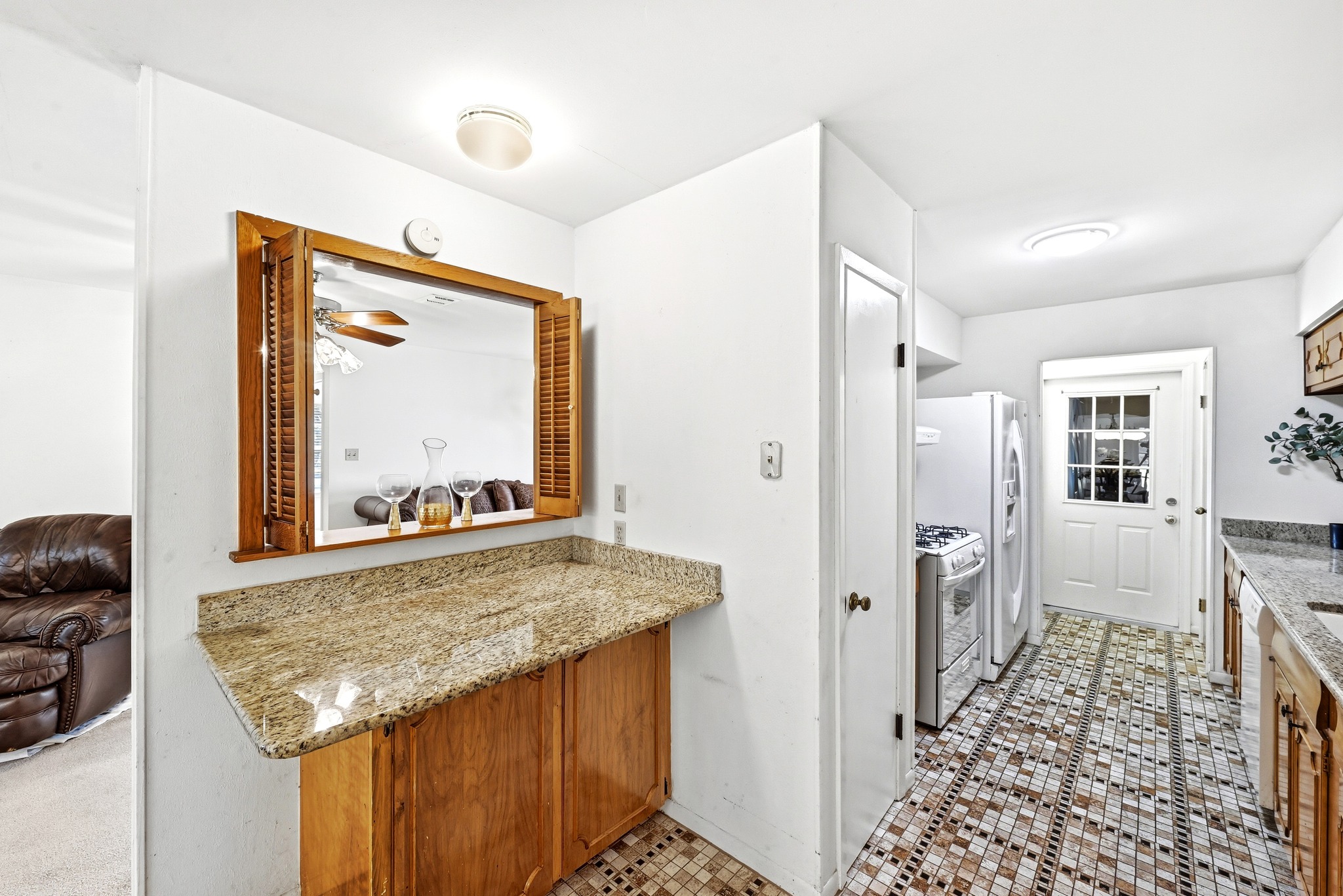 4619 Banister Lane Austin, TX 78745 - Photo 11 of 34 Kitchen with light stone counters, white appliances, and wood finish cabinets