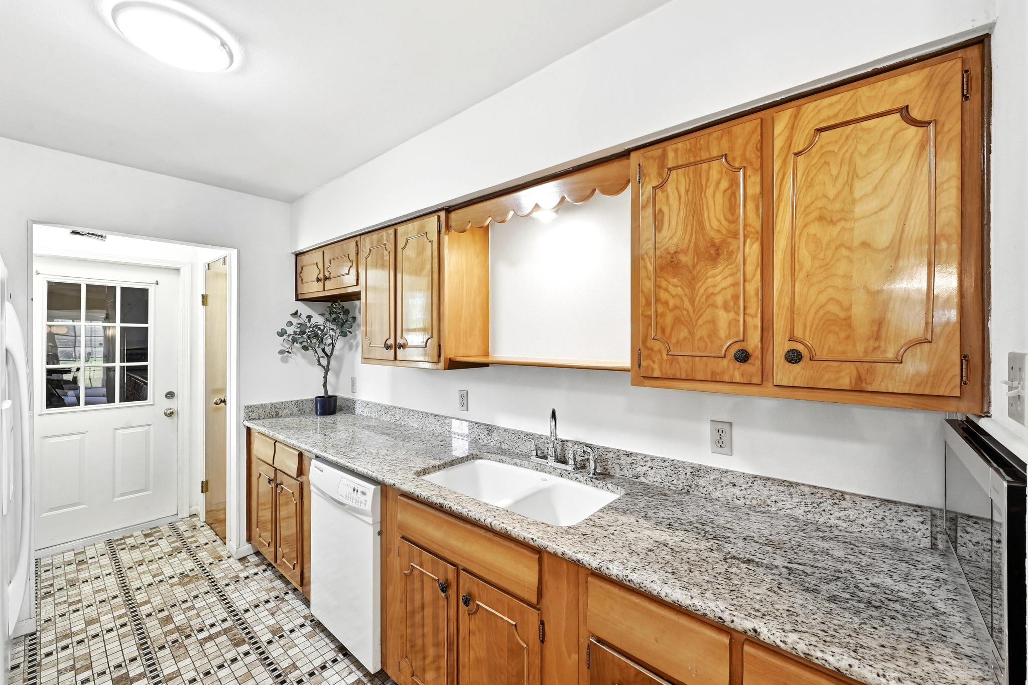 4619 Banister Lane Austin, TX 78745 - Photo 12 of 34 Kitchen with light stone counters, white appliances, and wood finish cabinetry