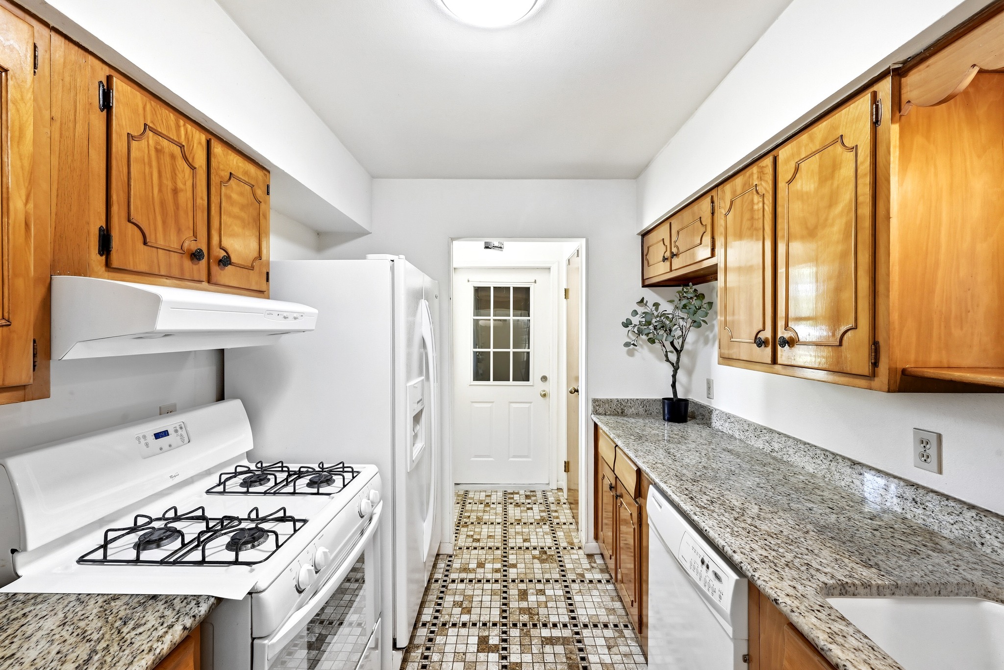 4619 Banister Lane Austin, TX 78745 - Photo 13 of 34 Kitchen with white appliances, wood finish cabinetry, and light stone countertops