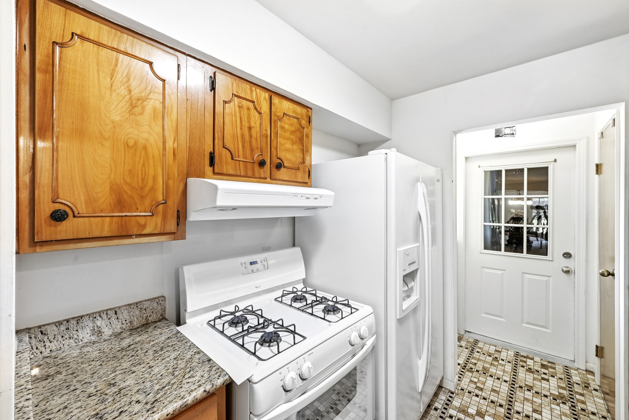 4619 Banister Lane Austin, TX 78745 - Photo 14 of 34 Kitchen featuring white appliances, wood finish cabinetry, and light stone counters