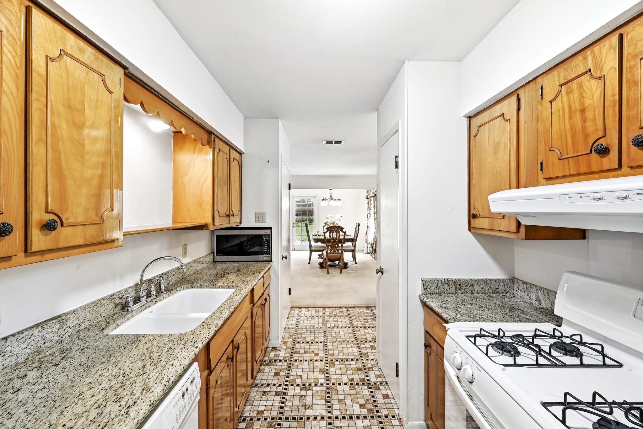 4619 Banister Lane Austin, TX 78745 - Photo 15 of 34 Kitchen featuring white appliances, light stone counters, exhaust hood, wood finish cabinetry, and light carpet