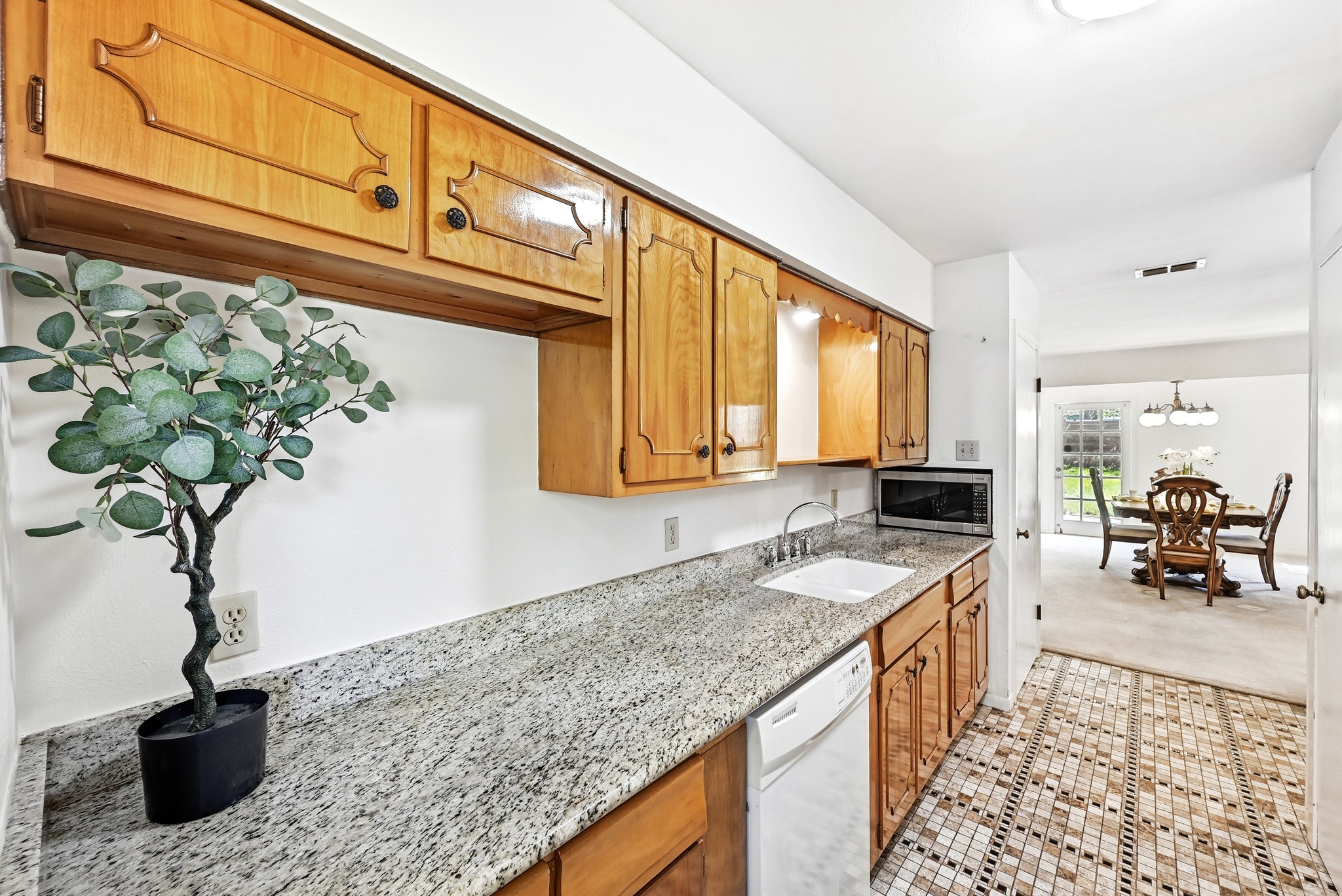4619 Banister Lane Austin, TX 78745 - Photo 16 of 34 Kitchen featuring dishwasher, light stone counters, stainless steel microwave, and wood finish cabinetry