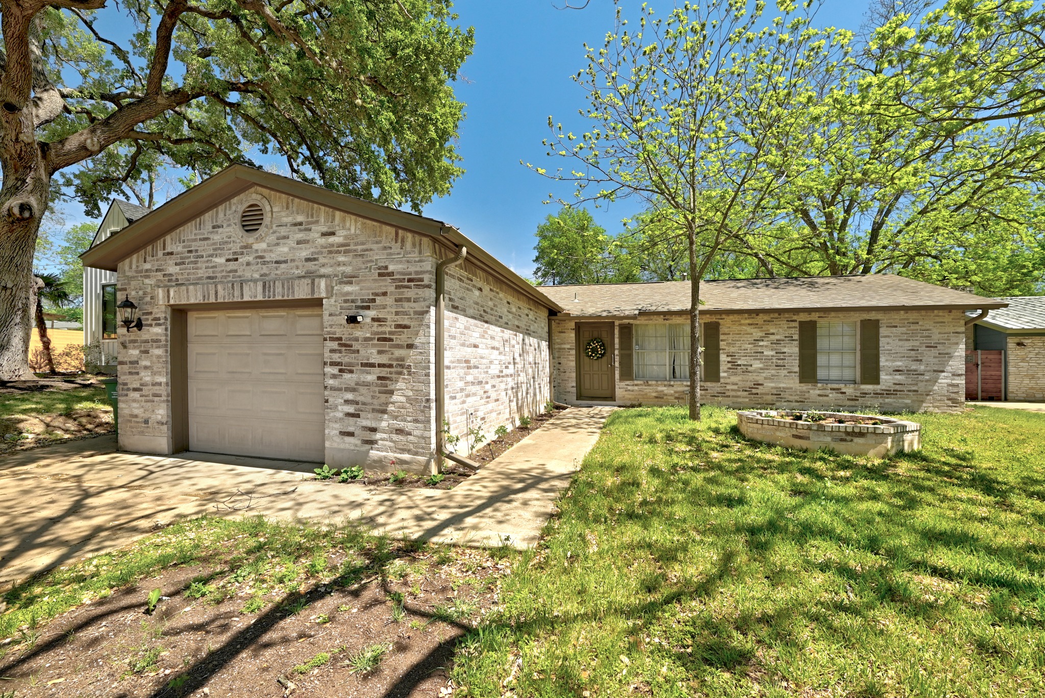 4619 Banister Lane Austin, TX 78745 - Photo 2 of 34 Ranch-style home featuring a garage, brick siding, and driveway