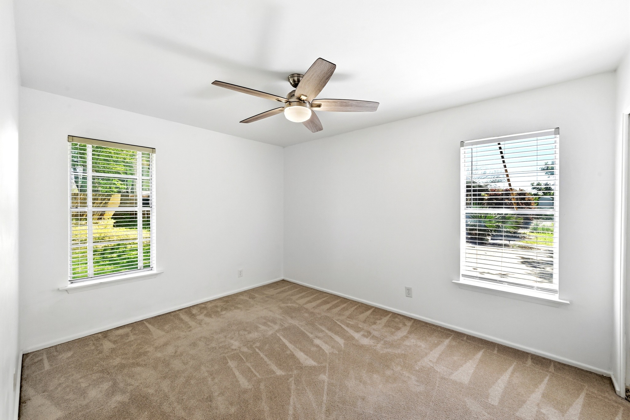 4619 Banister Lane Austin, TX 78745 - Photo 22 of 34 Unfurnished room featuring light colored carpet, ceiling fan, and plenty of natural light