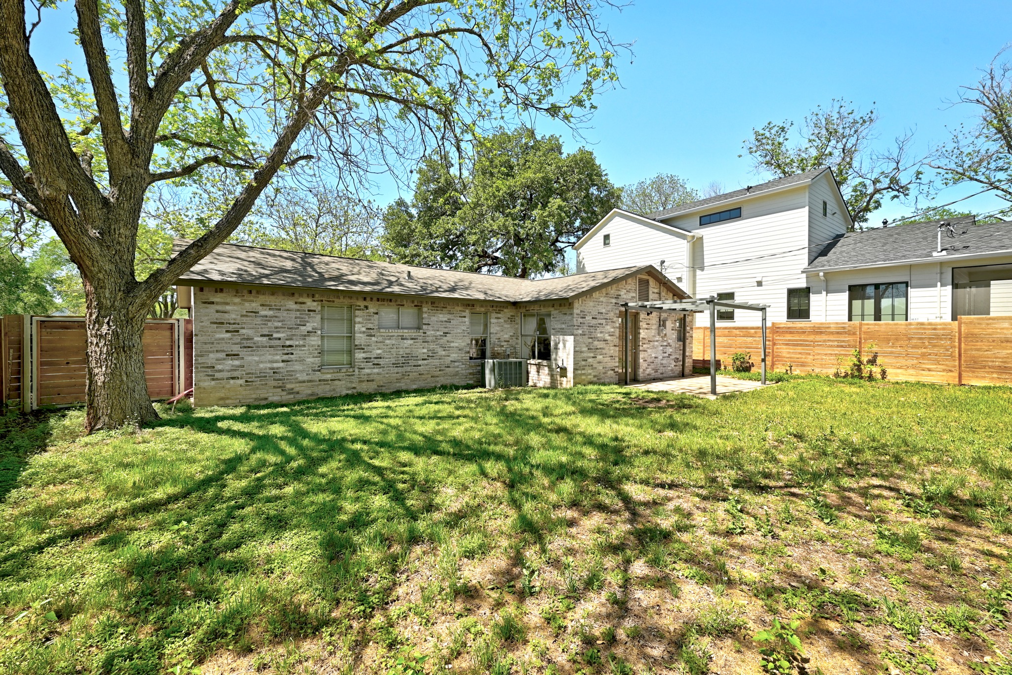 4619 Banister Lane Austin, TX 78745 - Photo 26 of 34 Back of house with brick siding, a fenced backyard, and a patio