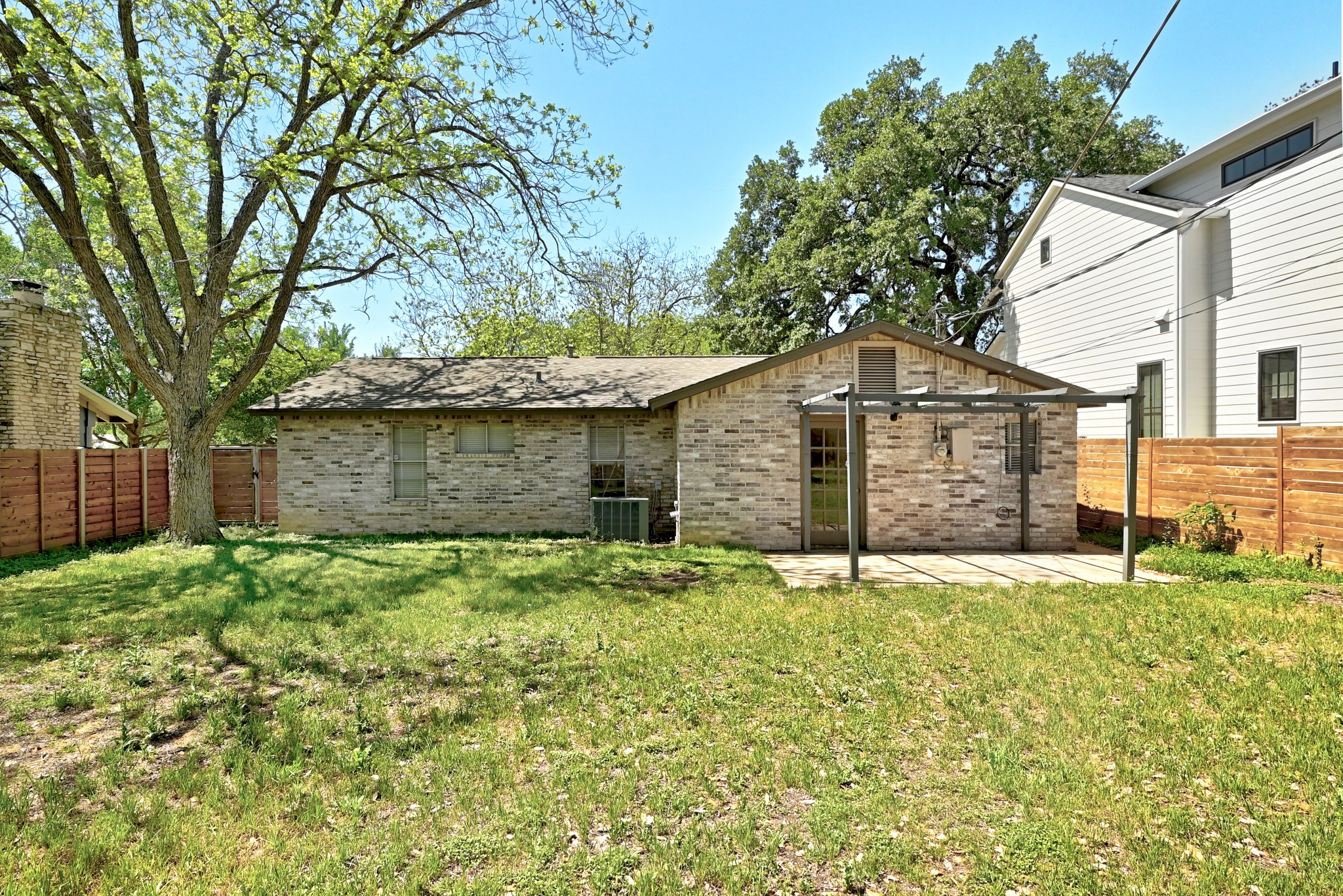 4619 Banister Lane Austin, TX 78745 - Photo 27 of 34 Back of house with a fenced backyard and brick siding